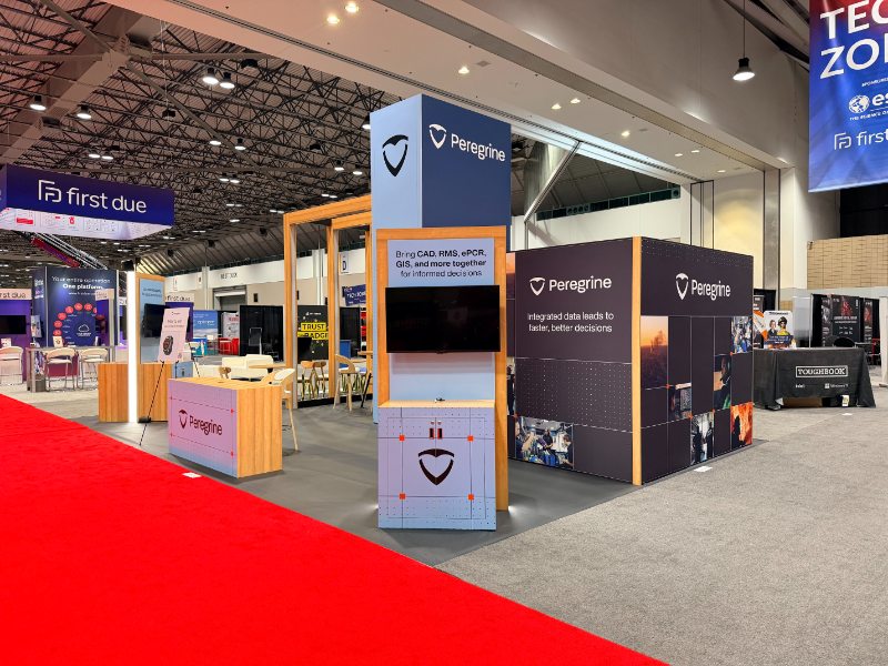 Aisle view of the Peregrine booth at FRI 2026 with the demo counter, tower, and graphic wall
